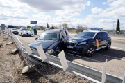 El vehículo, accidentado tras el uso de barreras de pinchos para parar la fuga, custodiado por agentes de la Policía Nacional y la Guardia Civil. LETICIA PÉREZ-ICAL