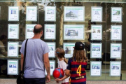 Una familia delante de una oficina inmobiliaria.-FERRAN NADEU