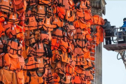 Asistentes del artista Ai Weiwei colocan chalecos salvavidas en la Kinzerthaus de Berlín, en recuerdo de los refugiados.-AFP / JOHN MACDOUGALL