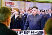 Dos personas miran en una gran pantalla de televisión la retransmisión de la ceremonia de conmemoración, en una estación de trenes de Seúl (Corea del Sur).-Foto: AFP / JUNG YEONG-JE