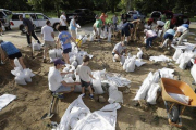 Vecinos de Baton Rouge colocan bolsas de arena para afianzar estructuras ant la inminente llegada de ’Barry’.-DAVID J. PHILLIP (AP)