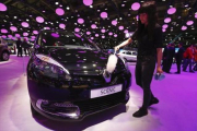 -Una empleada limpia un Renault en el Salón de Bruselas, ayer.