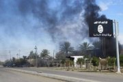 Humo negro tras la bandera de Estado Islámico después de que las fuerzas iraquís y chiís tomasen el control de Saadiya, el 24 de noviembre.-Foto: STRINGER IRAQ / REUTERS