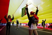 Voluntarios de Vox conducen una bandera de España de 1.000 metros cuadrados al acto del partido en la Plaza de Colón.-EFE / DAVID FERNÁNDEZ