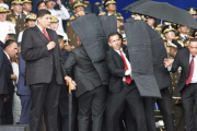 Personal de seguridad protege a Nicolás Maduro tras el atentado con drones en Venezuela.-AP / XINHUA