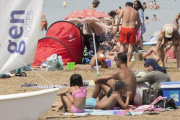 Una mujer en 'burkini', junto a su familia, en la playa de Roses.-JOAN CASTRO / ICONNA