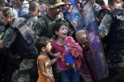 Dos niños lloran en un enfrentamiento entre inmigrantes y policía en la frontera de Grecia y Macedonia, en el 2015.-EFE / GEORGI LICOVSKI