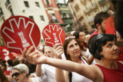 Unas mujeres muestran el símbolo de la campaña contra las agresiones sexistas en Sanfermines durante la manifestación ciudadana.-AP