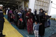 Refugiados y migrantes desembarcan del ferri 'Eleftherios Venizelos' a su llegada al puerto de Elefsina, a 20 kilómetros al noroeste de Atenas, procedentes de Lesbos, este lunes.-EFE / YANNIS KOLESIDIS