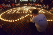 Familiares de pasajeros del vuelo Malaysia Airlines MH370 rezan en el Metro Park Hotel en Pekin.-Foto: AFP / WANG ZHAO