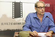 El director del certamen, Javier Muñiz, frente al cartel ganador. / VALENTÍN GUISANDE-