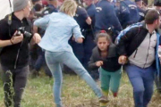 Imagen de un video en la que se ve a la reportera Petra László como hace la zancadilla a una niña refugiada que huye de la policía en el campo de Roszke.-AFP