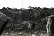 Agentes de las fuerzas de seguridad afganas inspeccionan la zona del atentado, en las afueras de Kabul.-AFP / WAKIL KOHSAR