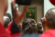 Aglomeración de visitantes frente a La Gioconda, en el Museo del Louvre.-DANIEL MORDZINSKI