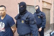 Imagen cedida por la Cadena Ser, en la que dos mossos se llevan detenido, en Santa Coloma de Gramenet, a uno de los presuntos miembros de la banda de Latin Kings desarticulada este miércoles.-Foto: CADENA SER