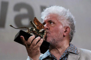 Pedro Almodóvar besa el León de Oro a su carrera cinematográfica, en Venecia, este jueves.-MANUEL SILVESTRI