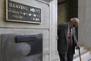 Un anciano griego sale de la sucursal de un banco.-Foto: AP / THANASSI STAVRAKIS