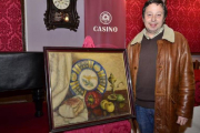 El presidente del casino, Adolfo Saínz, con el cuadro donado por el madrileño Ignacio Martínez de Velasco. / ÁLVARO MARTÍNEZ-