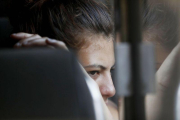 Una migrante hondurena mira por la ventana del autobus que la regresara voluntariamente a Honduras desde Tecun Uman, Guatemala.-EFE / ESTEBAN BIBA