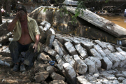 Un hombre, junto a los restos de su casa, arrasada por las inundaciones en Trujillo (Perú).-STRINGER / REUTERS