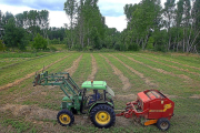 Un agricultor realiza trabajos de empacado de hierba en una finca de Ponferrada.-ICAL
