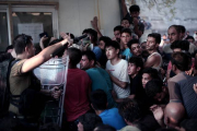 La policía helena carga contra los inmigrantes que esperan para registrarse en el puerto de Mitelene, en la isla de Lesbos.-AFP / ANGELOS TZORTZINIS
