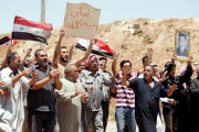 Un grupo de civiles celebra la entrada de las tropas del régimen en Deraa. /-OMAR SANADIKI / REUTERS