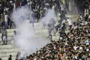 Los aficionados de Vasco da Gama se enfrentan con la policía durante el partido de su equipo contra el Flamengo.-EFE / ANTONIO LACERDA