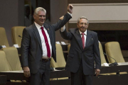 Raúl Castro (derecha) levanta el brazo del nuevo presidente de Cuba, tras ser nombrado oficialmente por la Asamblea Nacional, en La Habana, el 19 de abril.-AFP