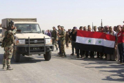 Vecinos de la aldea de Ghebesh dan la bienvenida a las tropas sirias.-AP