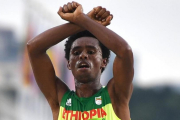 El atleta etíope Feyisa Lilesa cruzando la línea de meta tras acabar segundo en el maratón de Río.-OLIVIER MORÍN / AFP