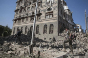 Dos rebeldes yemeníes inspeccionan las ruinas de edificios destruidos por los bombardeos en Saná.-HANI MOHAMMED (AP)