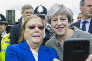 May (derecha) posa para un selfi con una asistente a una exhibición militar en Liverpool, el 24 de junio.-OWEN COOBAN