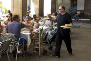 Un camarero sirve a un grupo de clientes en una terraza.-JOSEP GARCÍA
