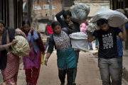 Ciudadanos de Bhaktapur, en Nepal, acarreando sus enseres.-Foto: AFP / BERNAT ARMANGUE
