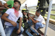 Una mujer afectada por los gases lacrimógenos es atendida por sus compañeros en el puente inetrnacional Simón Bolívar, en Cúcuta (Colombia), el 23 de febrero del 2019.-AP / FERNANDO VERGARA