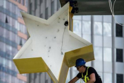 Un operario trabaja en la escultura del logo del euro ante la anterior sede del BCE en Francfort.-AFP / BORIS ROESSLER