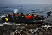Un migrante afgano salta de una sobresaturada patera al alcanzar la playa en Lesbos (Grecia), el 19 de octubre del 2015.-YANNIS BEHRAKIS