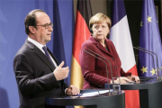 Hollande y Merkel, en la rueda de prensa tras la reunión del Cuarteto de Normandía.-MICHAEL KAPPELER / EFE
