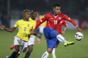 El defensa chileno Gonzalo Jara (d) controla el balón ante el delantero ecuatoriano Fidel Martínez (i).-Foto: EFE