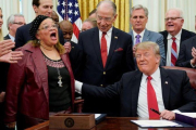 Donald Trump toca a Alveda King, evangelista y sobrina de Luther Martin King, que habló durante la ceremonia de la firma de la Ley Primer Paso, en el Despacho Oval de la Casa Blanca, el 21 de ediciembre del 2018.-REUTERS / JOSHUA ROBERTS