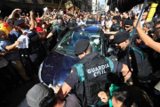 Mossos ayudan a guardias civiles a salir de una concentración de protesta ante la Conselleria dAfers Exteriors.-FERRAN NADEU