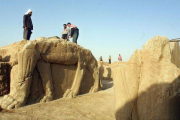 Trabajadores iraquís limpian las estatuas en el sitio arqueológico de Nimrod, en el 2001.-Foto: AFP / KARIM SAHIB