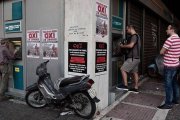 Colas ante cajeros en Atenas, con carteles a favor del 'no' en el referendum.-Foto: AFP