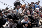 Refugiados sirios esperan cruzar desde su país la frontera que les separa de Turquía  cerca de Akcakale en la provincia de Sanliurfa.-EFE / SEDAT SUNA