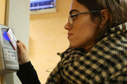 Una trabajadora ficha en un aparato de control horario al empezar su jornada.-ELISENDA PONS