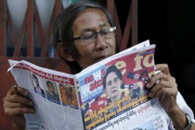Un birmano lee un periódico donde Suu Kyi aparece en portada, este sábado.-EFE / RUNGROJ YONGRIT