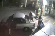 Imagen de la grabación de una cámara de seguridad en que se ve como unos ladrones intentan llevarse un gran botín de tabaco en un saco tan grande que no les cabe en el coche.-