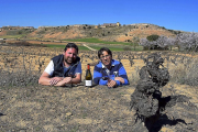 De izquierda a derecha, Jaime e Ismael, junto a la cepa centenaria y, de fondo, la bodega Dominio de Atauta, situada en una ladera, entre los dos célebres palomares-Agricomunicación