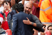 Pep Guardiola y Unai Emery (de espaldas) se saludan antes del Arsenal-Manchester City.-REUTERS / JOHN SIBLEY